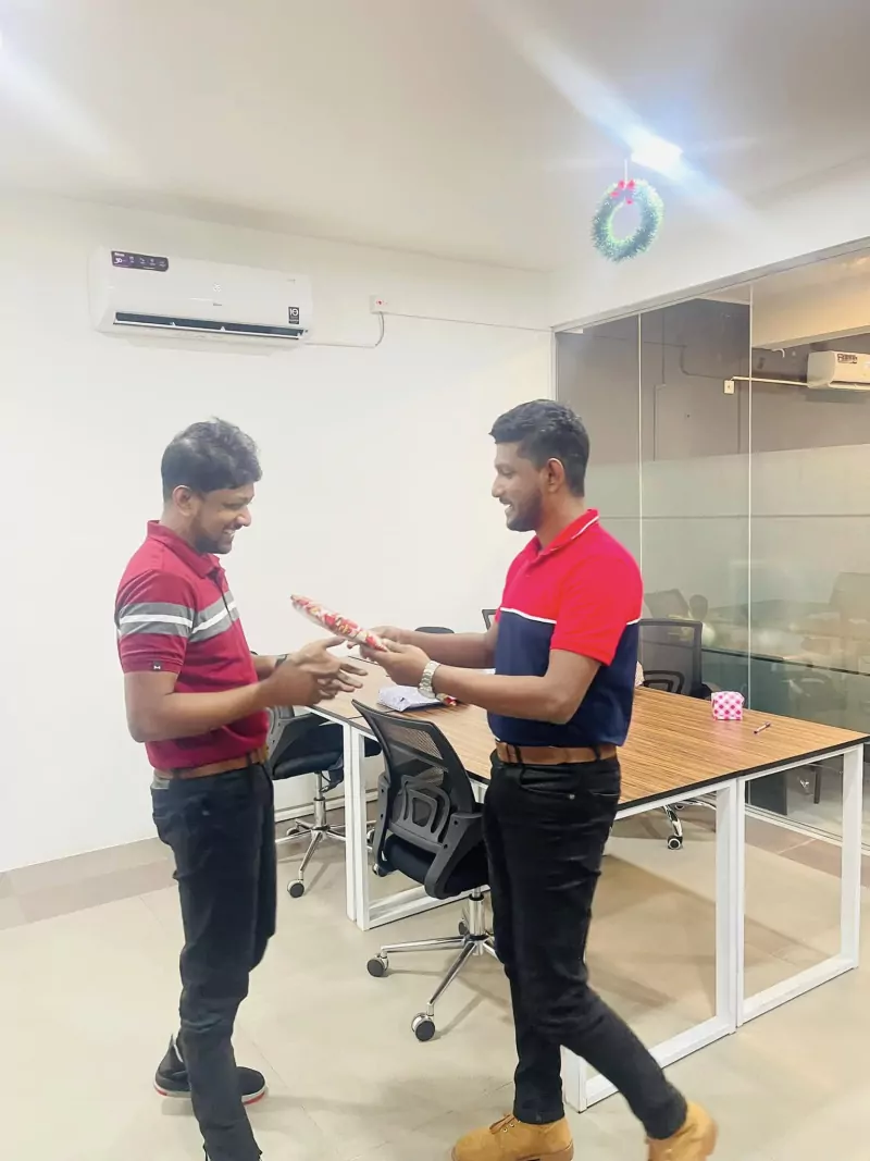 Team members exchanging a Christmas gift at the office