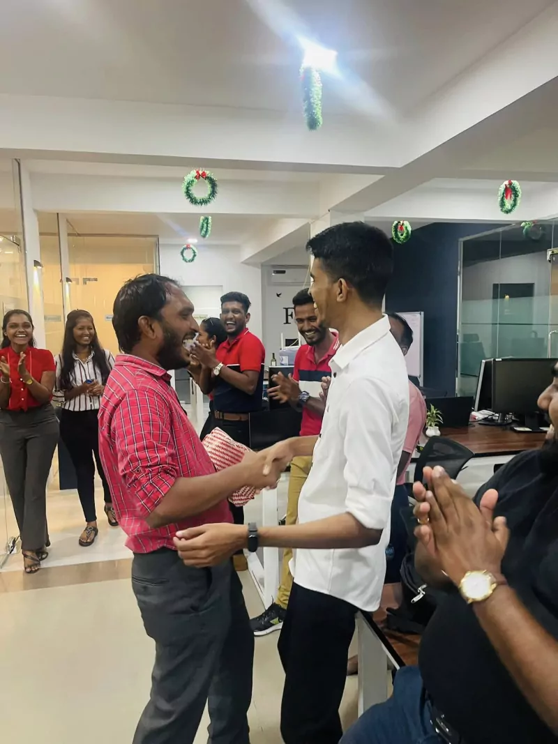 Team members sharing gifts during the office Christmas celebration